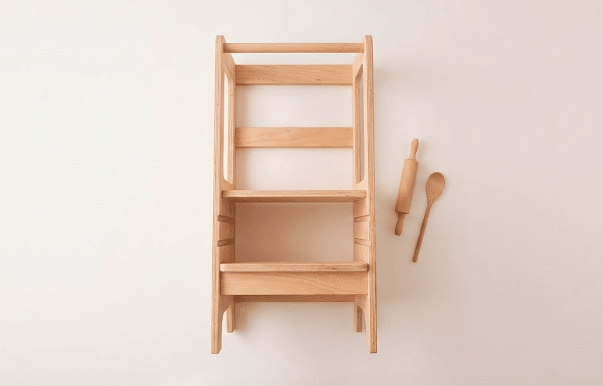 Enfant utilisant une tour d’observation Montessori dans la cuisine